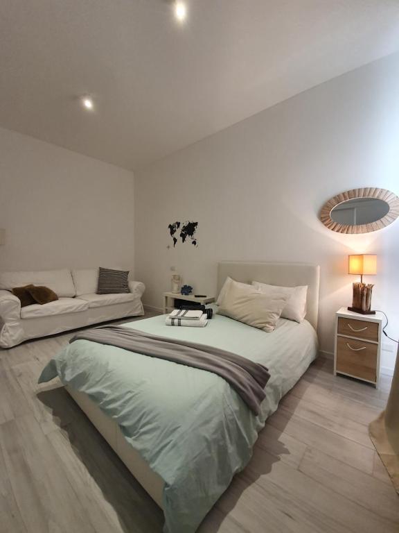 ein weißes Schlafzimmer mit einem großen Bett und einem Sofa in der Unterkunft San Siro Suite fiera in Mailand