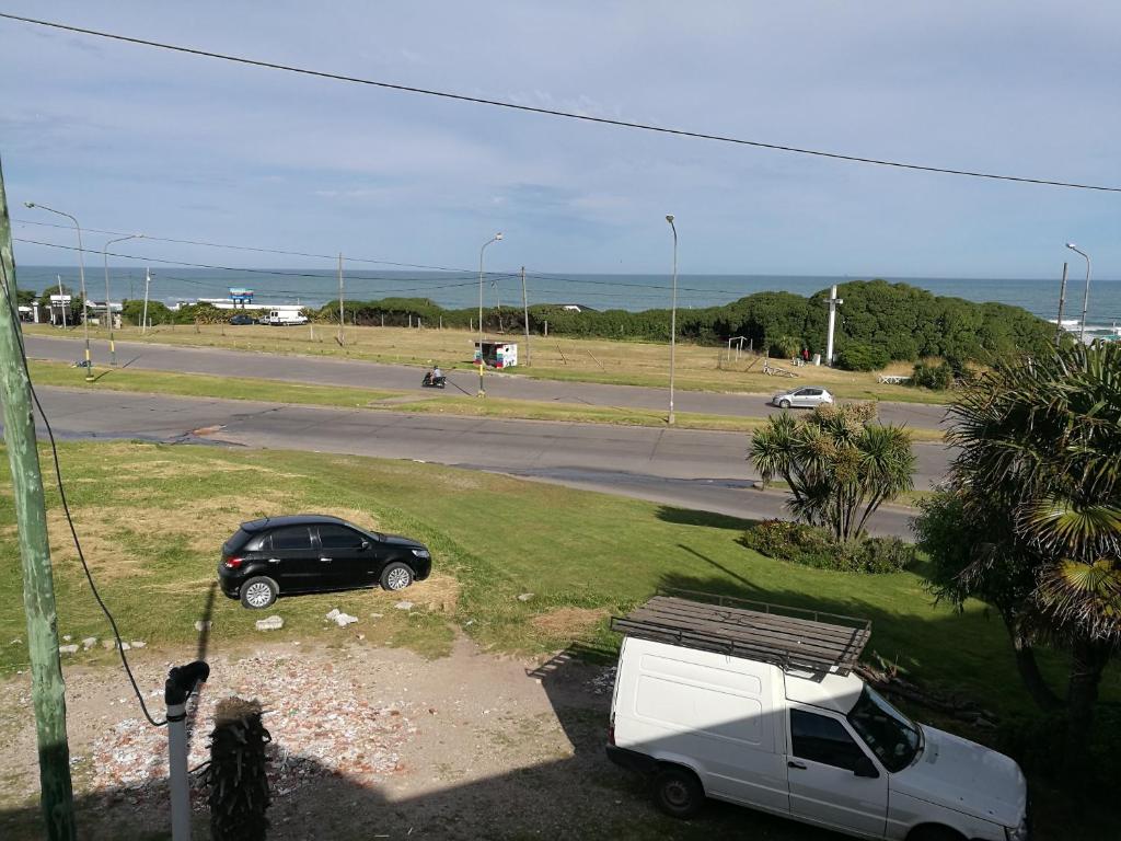 un coche y una furgoneta estacionados al lado de una carretera en Casa duplex Frente AL Mar familiar Depto A en Mar del Plata