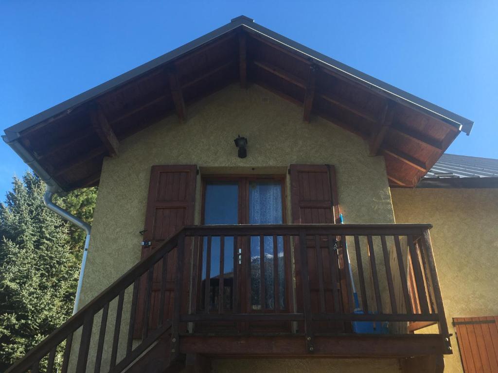 un balcone di una casa con porta in legno di Studio à la montagne a Briançon
