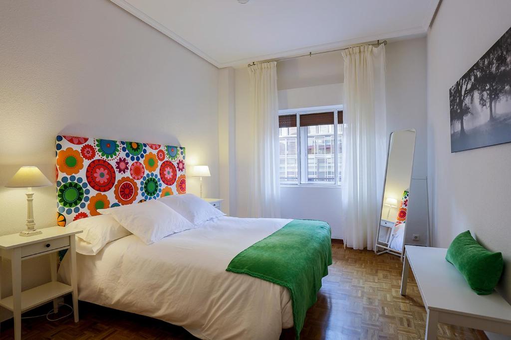 Dormitorio con cama grande y cabecero colorido en Valladolid Centro Enrique IV, en Valladolid