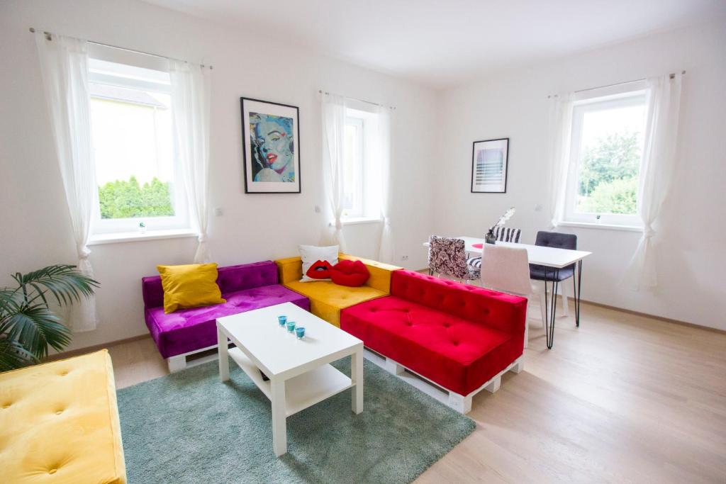 a living room with colorful couches and a table at DAREBELL Apartment Gratkorn Top 2 in Gratkorn