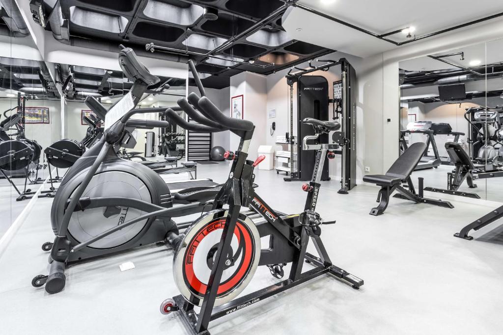 A bright, mirrored gym with cardio and resistance equipment.