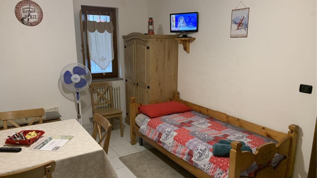 a bedroom with a bed and a table and a television at Le JOLI COIN DU PASSAGE - CIR 0306 in Aosta