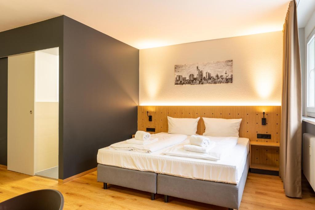 フランクフルト・アム・マインにあるmk ホテル フランクフルトのベッドルーム(白いシーツを使用した大型ベッド1台付)