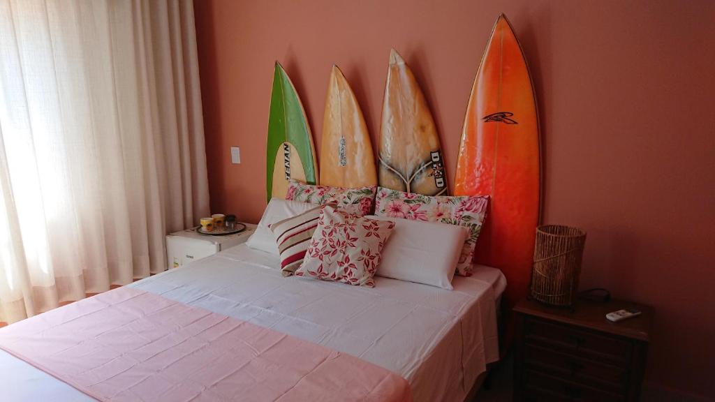 a room with a bed with four surfboards on the wall at Guarujá Comfort & Design in Guarujá