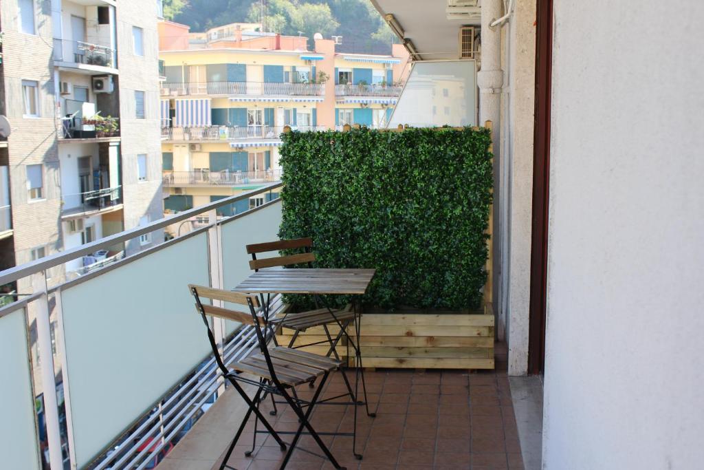balkon z 2 krzesłami i zielonym żywopłotem w obiekcie San Vitale House w mieście Neapol