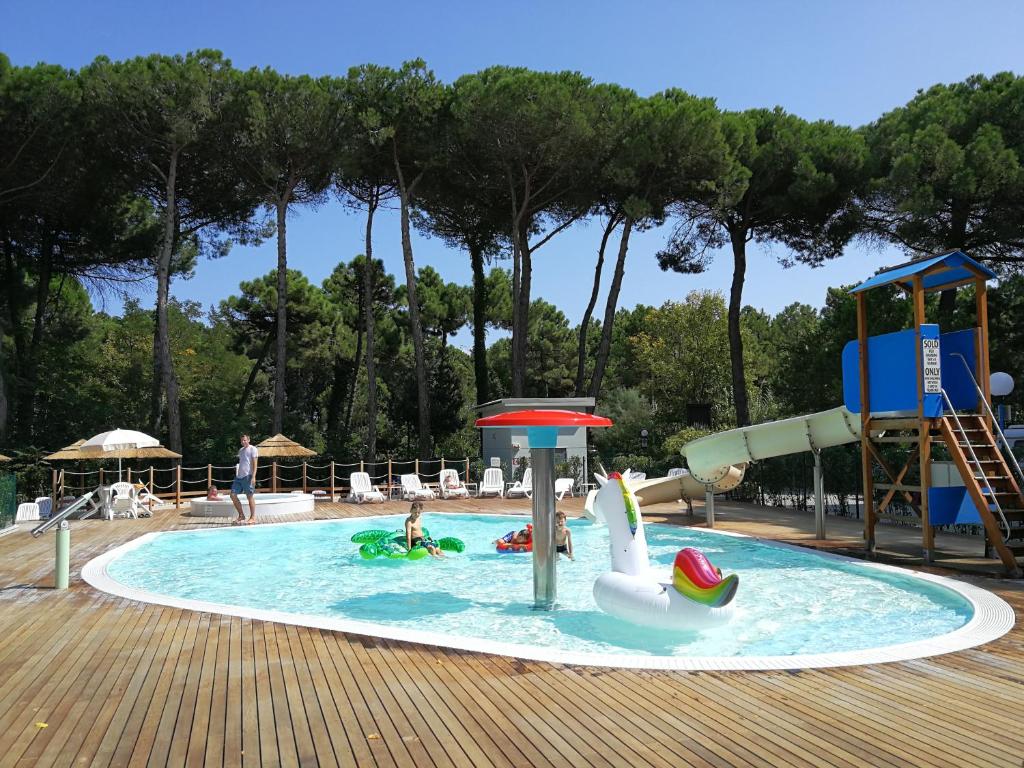 uma piscina com um cisne e um escorrega em Piomboni Camping Village em Marina di Ravenna