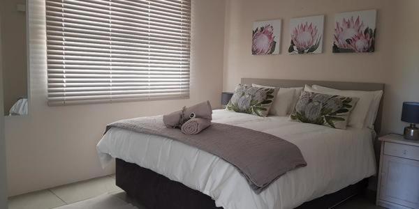 a bedroom with a bed with a laptop on it at Mayfair Farm Cottages in Oudtshoorn