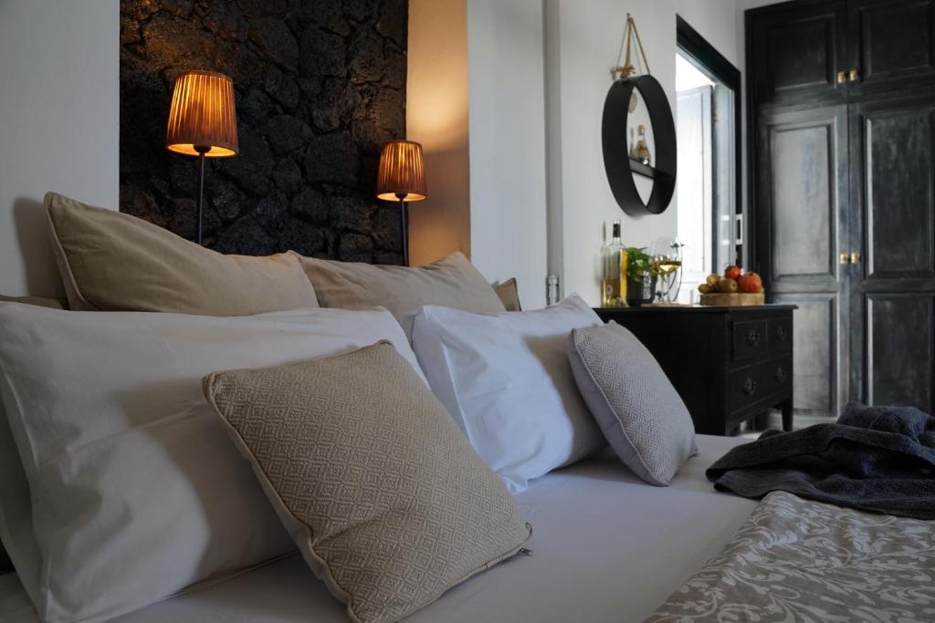 a bedroom with a white bed with pillows and a mirror at B&B La Mimosa in Teguise