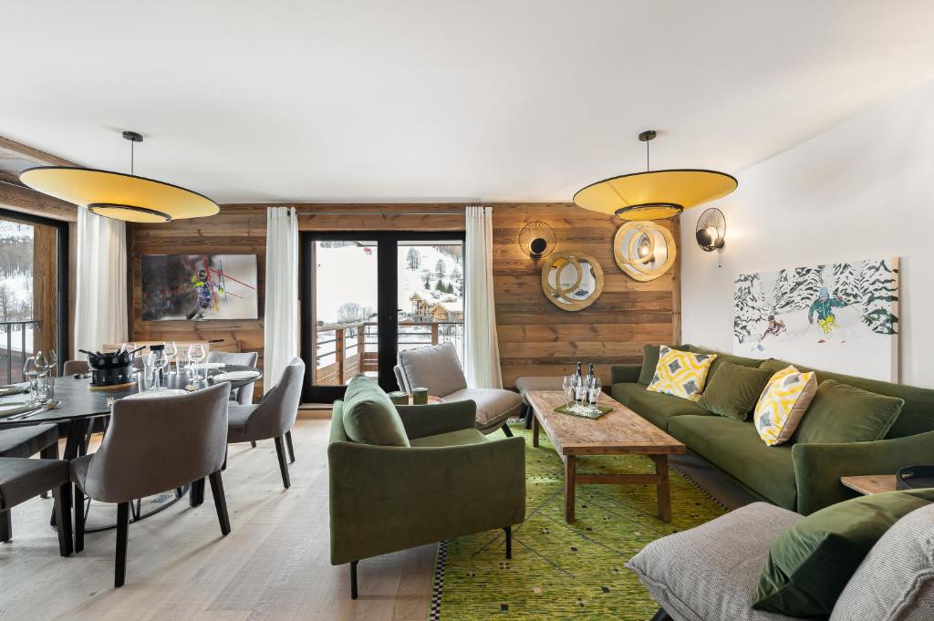 uma sala de estar com mobiliário verde e uma sala de jantar em Appartement Ourson - LES CHALETS COVAREL em Val dʼIsère