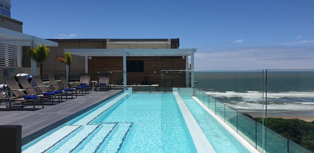 a swimming pool on a building with a view of the ocean at Blue Waters Hotel in Durban