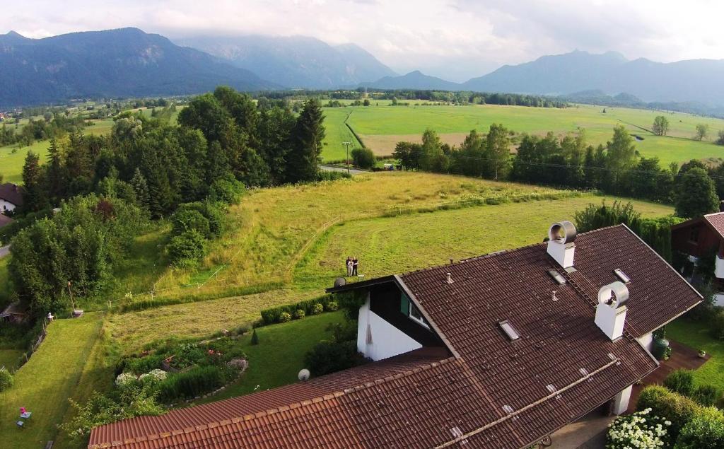 an aerial view of a house with a field and mountains at Ferienwohnung Murnauer Moos in Murnau am Staffelsee