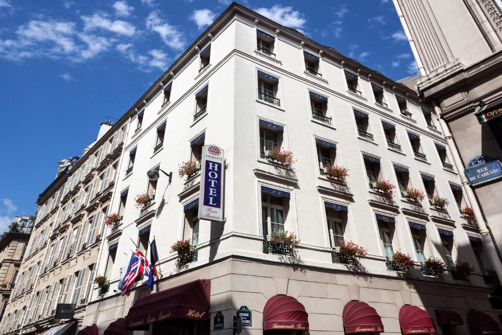 a large white building with a flag on the side of it at Amarante Beau Manoir in Paris