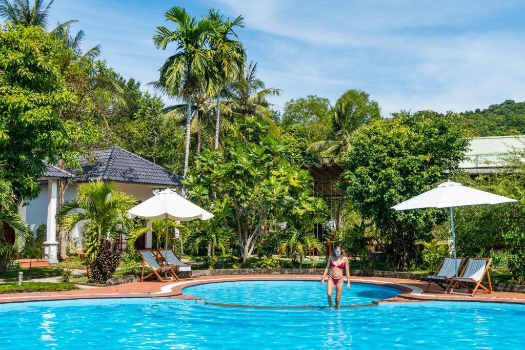 une femme debout dans l'eau dans une piscine d'un complexe dans l'établissement Long Mountain Resort, à Duong Dong