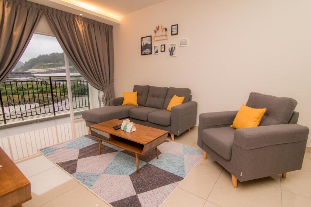 Cameron Highlands Modern7-Tea Plantation View-Premium Hotel Bed في Kampung Kuala Terla: غرفة معيشة مع كنبتين وطاولة قهوة