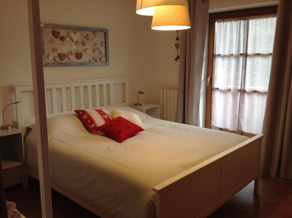 een slaapkamer met een bed met 2 rode kussens bij VILLA ROOMS in Laives