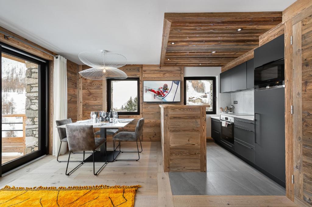 een keuken met een tafel en stoelen in een kamer bij Appartement Flocon - LES CHALETS COVAREL in Val dʼIsère