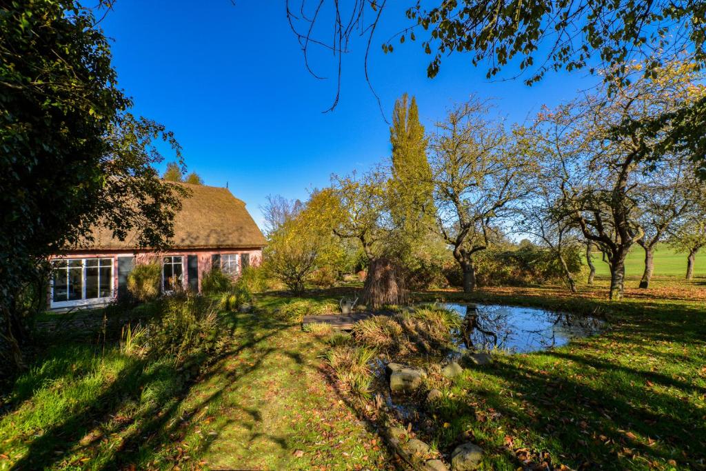 una casa rural con un estanque en el patio en Hof Garz, en Poseritz