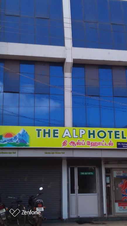 a building with a sign for a hotel at THE ALP HOTEL in Madurai