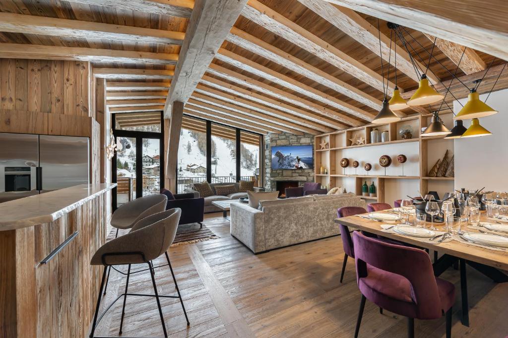 a dining room and living room with a table and chairs at Penthouse Flèche - LES CHALETS COVAREL in Val-d'Isère