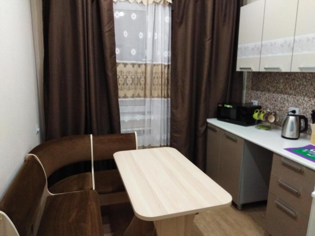 una pequeña cocina con una mesa de madera y una encimera en 2- х комнатные апартаменты на Олимпийской Зима-Лето en Kirovsk