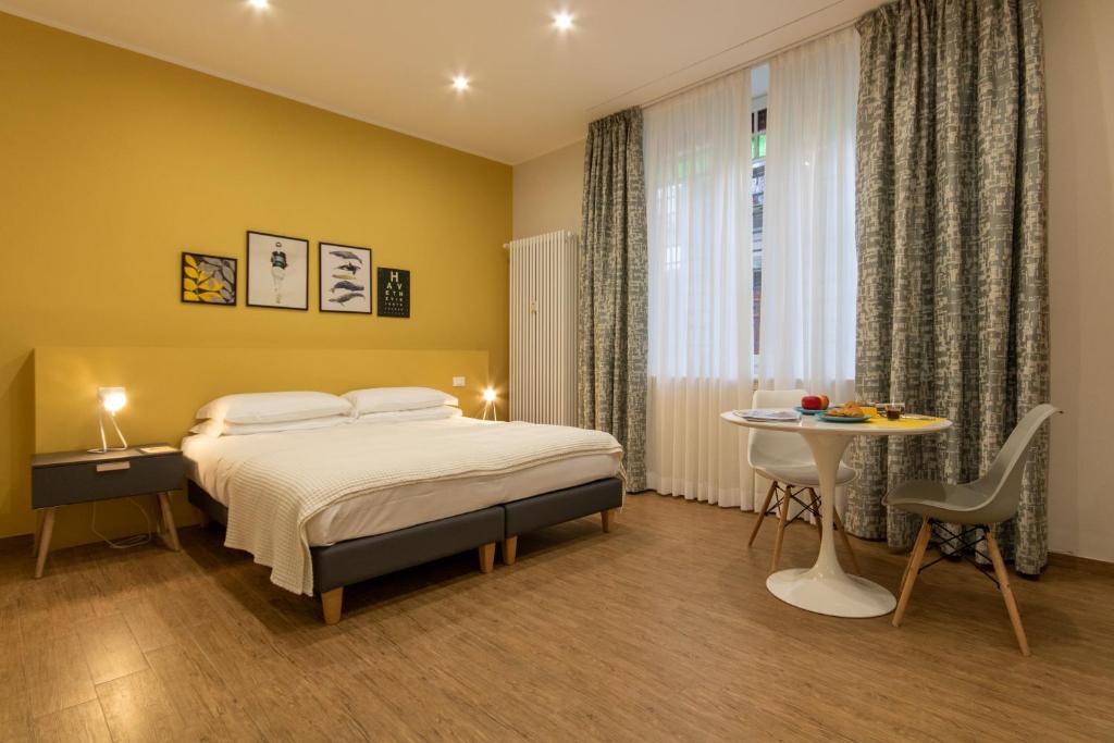 a bedroom with a bed and a table and a window at Aqualago casa vacanze apartment A in Verbania