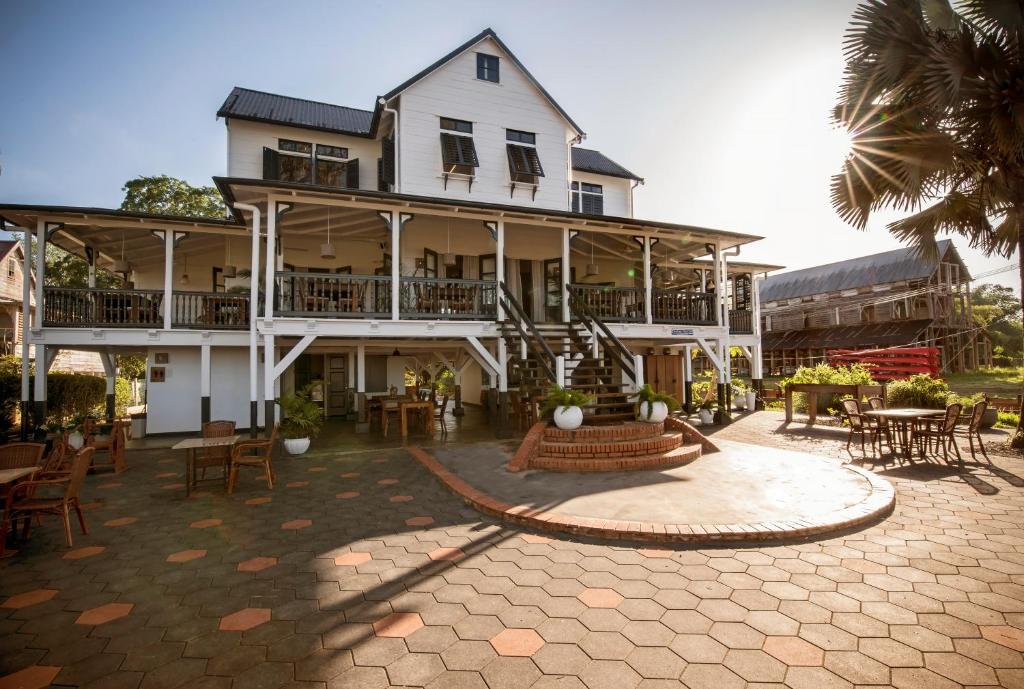 ein großes Haus mit einem Innenhof mit Tischen und Stühlen in der Unterkunft Boutique Hotel Peperpot in Meerzorg