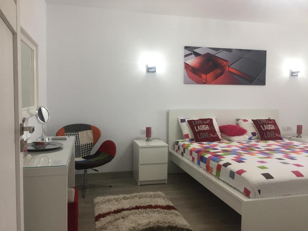 1 dormitorio con cama, mesa y escritorio en Luxury Apartment, en Galaţi