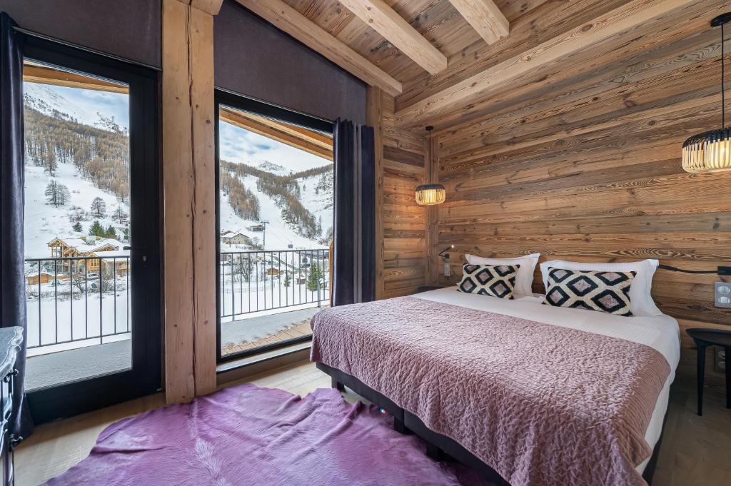 a bedroom with a bed and a large window at Penthouse Chamois - LES CHALETS COVAREL in La Daille