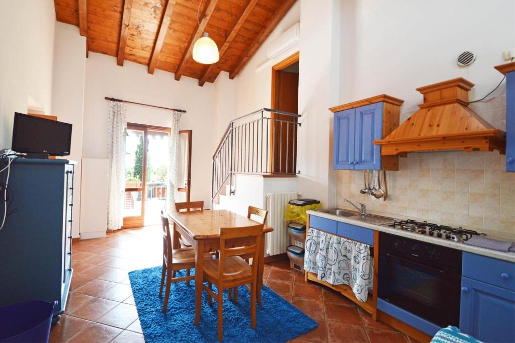 a kitchen with blue cabinets and a table with chairs at Agriturismo La Filanda in Manerba del Garda