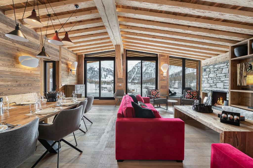 sala de estar con sofá rojo y chimenea en Penthouse Chamois - LES CHALETS COVAREL en La Daille