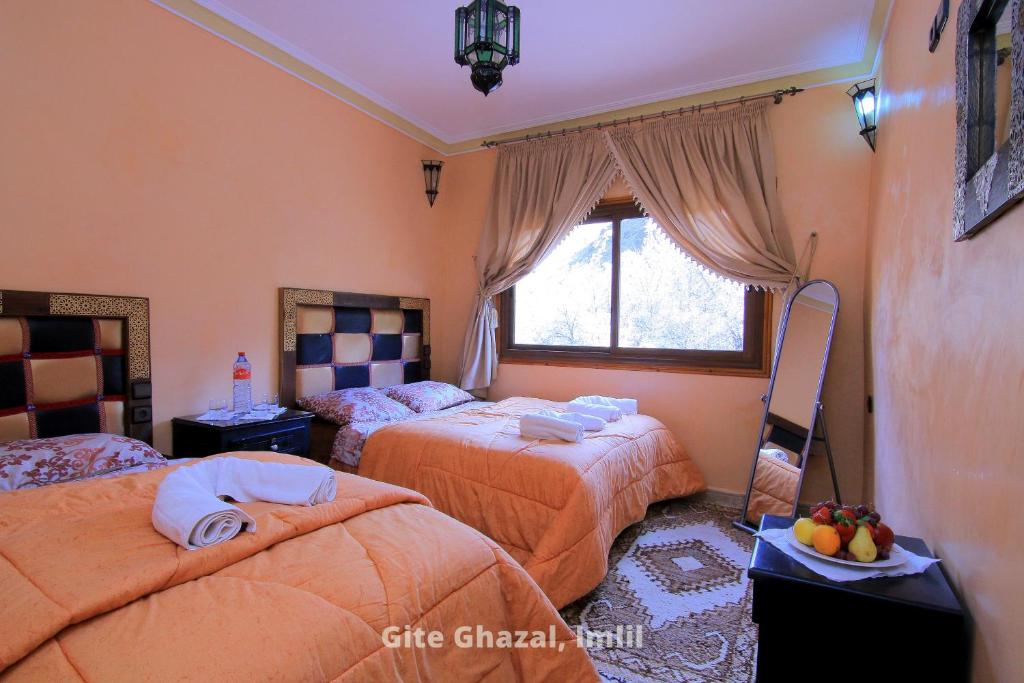 1 dormitorio con 2 camas y ventana en Gite Ghazal - Atlas Mountains Hotel en Imlil