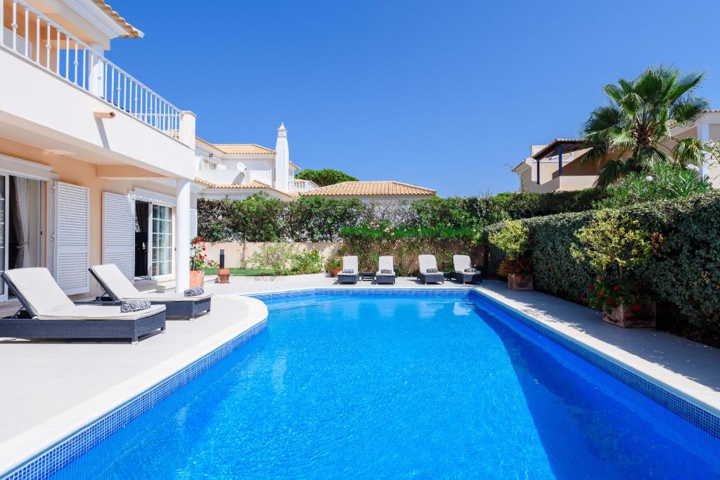 una piscina con sillas y una casa en Casa Lago, en Quinta do Lago