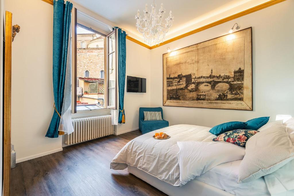 佛羅倫斯的住宿－Lorenzo de' Medici Family Home，卧室配有一张床,墙上挂着一幅画