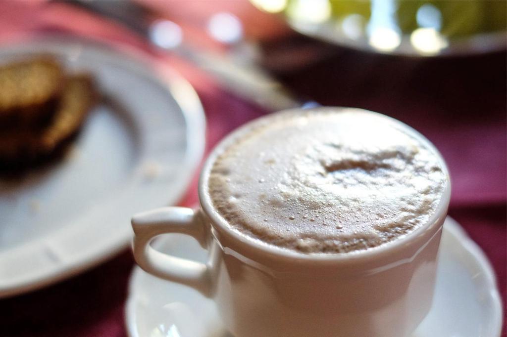a cup of coffee on a table with a plate of food at Agriturismo La Filanda in Manerba del Garda