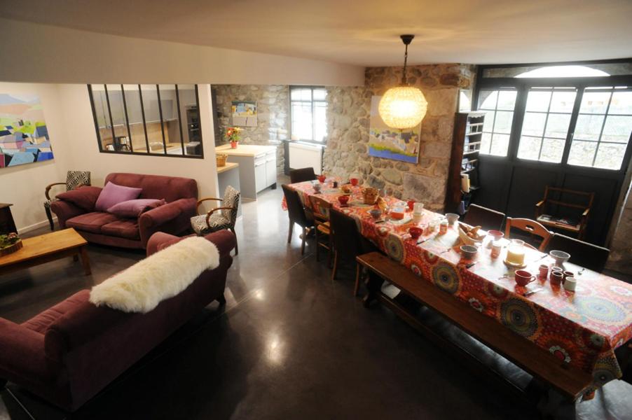 ein Wohnzimmer mit einem langen Tisch und einer Couch in der Unterkunft Gite de la Ferme de Maria Blanca in Bielle