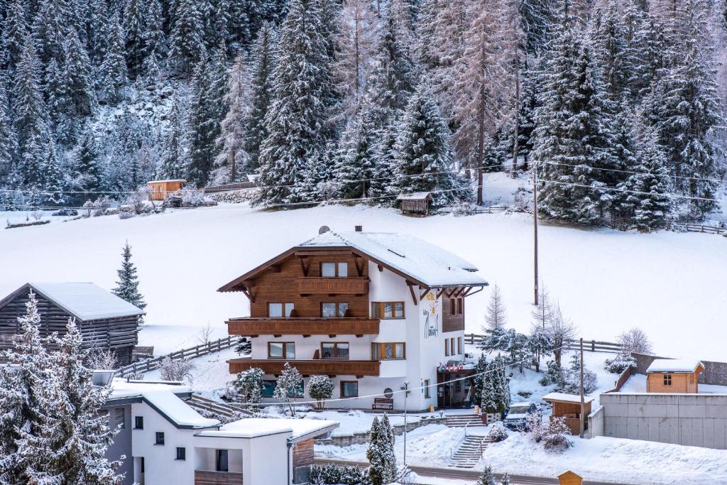 una casa en la nieve con árboles nevados en Intermontana Familienhotel B&B, en Sankt Leonhard im Pitztal