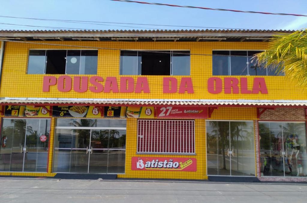 a yellow building with a sign that reads potassium da olia at Pousada da Orla in Salinópolis