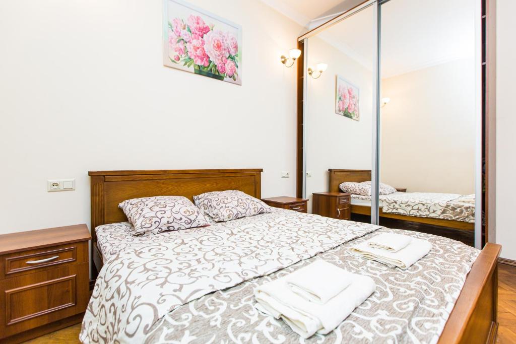 a bedroom with a large bed and a mirror at Квартира в центрі вулиця Балабана 29 біля Краківського ринку in Lviv