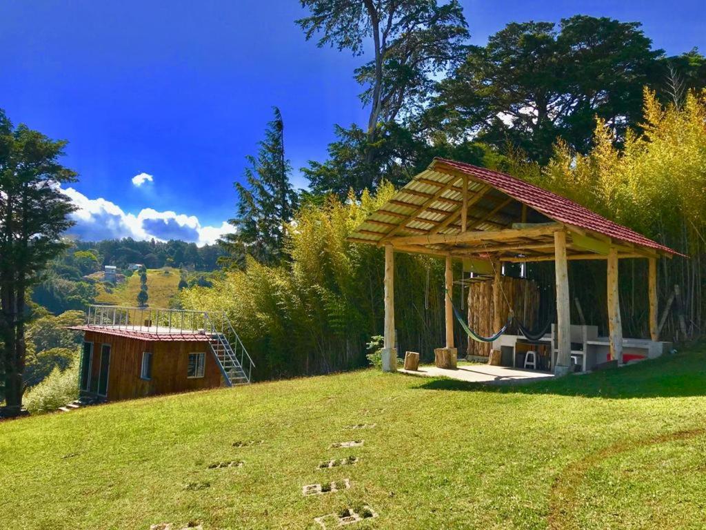 a gazebo on the side of a grass field at Cabaña Mountain View in Heredia