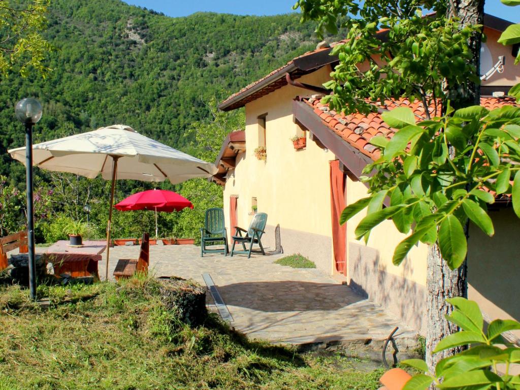 FornovolascoにあるSplendid Cottage in Vergemoli with Barbecue and Gardenのパティオ(パラソル、テーブル、椅子付)