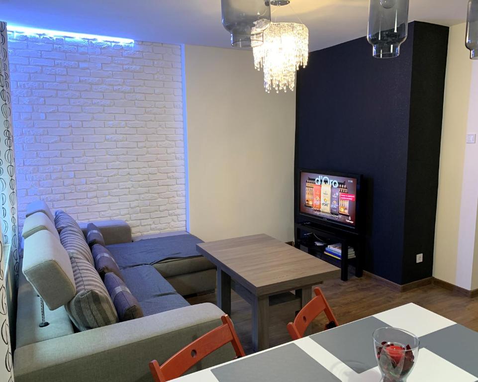 ein Wohnzimmer mit einem Sofa und einem TV in der Unterkunft Apartament rodzinny 70 m2 in Tarnowitz