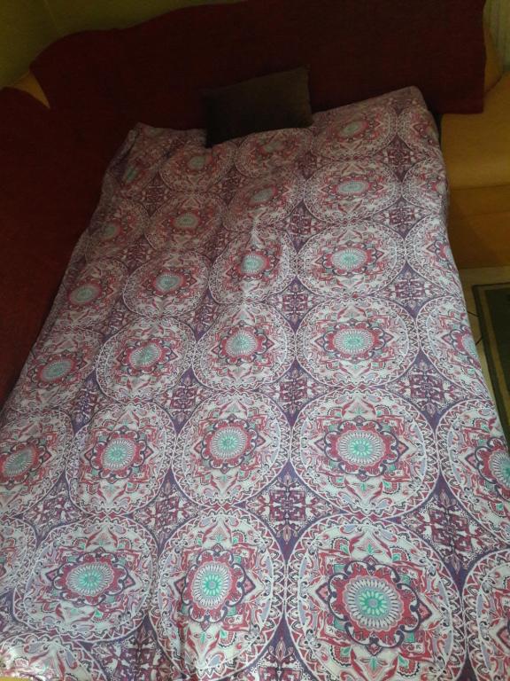 una cama con colcha estampada encima en Bela apartment, en Belá