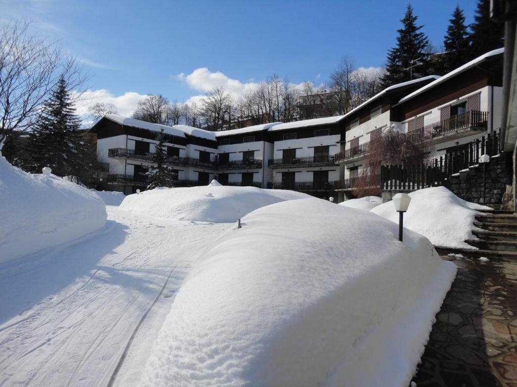 une pile de neige devant un bâtiment dans l'établissement Residence Il Mulinaccio, à Pievepelago