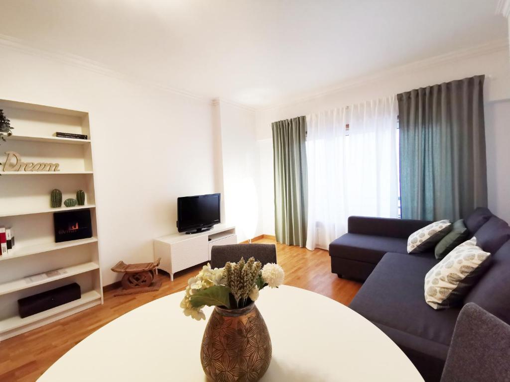 Down Town Apartment - EXPO27 في لشبونة: غرفة معيشة مع أريكة وطاولة