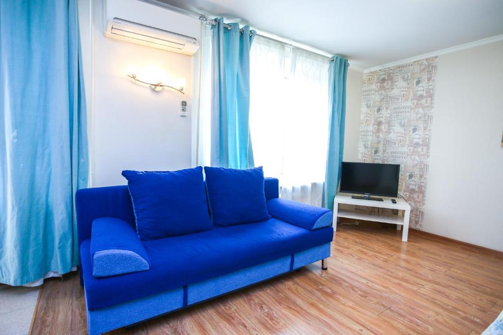 モスクワにあるApartment Na Trekhgornom Valuのリビングルーム(青いソファ、テレビ付)