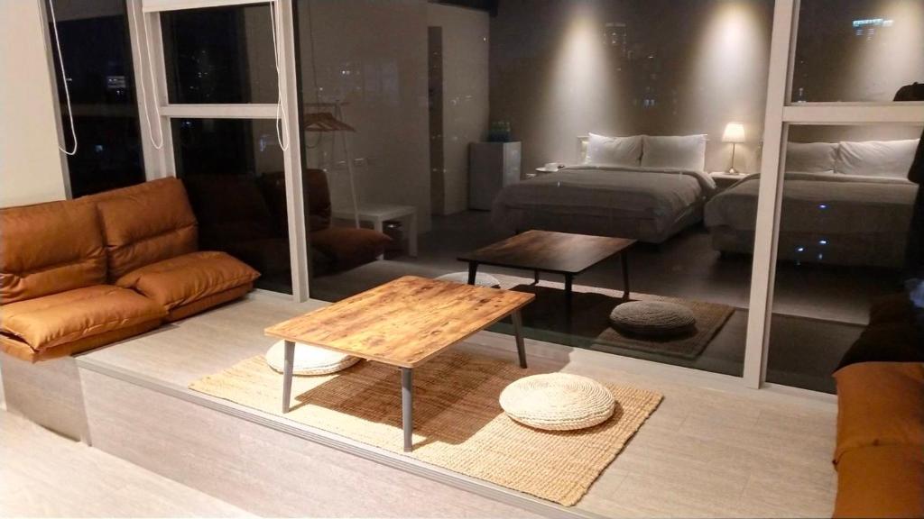 um quarto com um sofá, uma cama e uma mesa em 想想逢甲 Shine Residence em Taichung