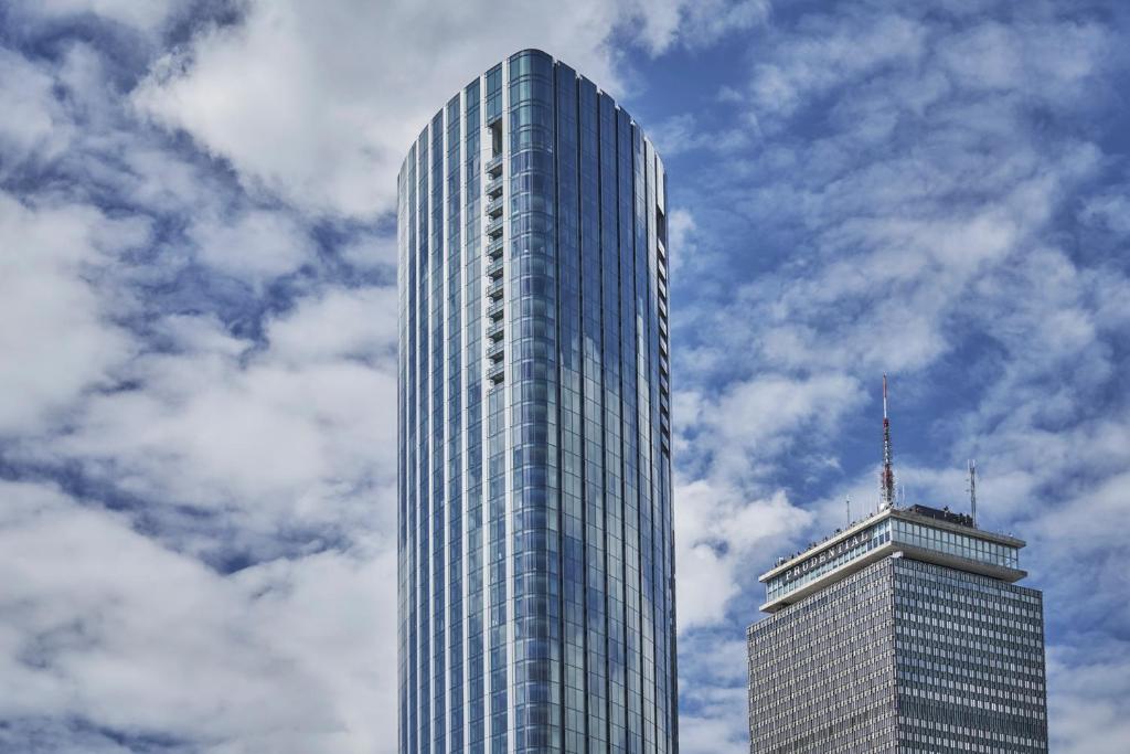 a tall glass building with a sky background at Four Seasons Hotel One Dalton Street, Boston in Boston