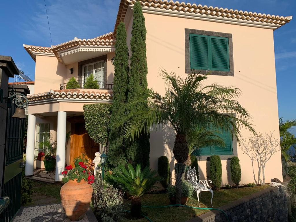 a house with trees and plants in front of it at Vila Tagus Garajau in Caniço