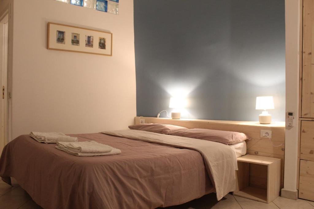 パレルモにあるMediterraneoのベッドルーム1室(ベッド2台付)、壁にランプ2つ